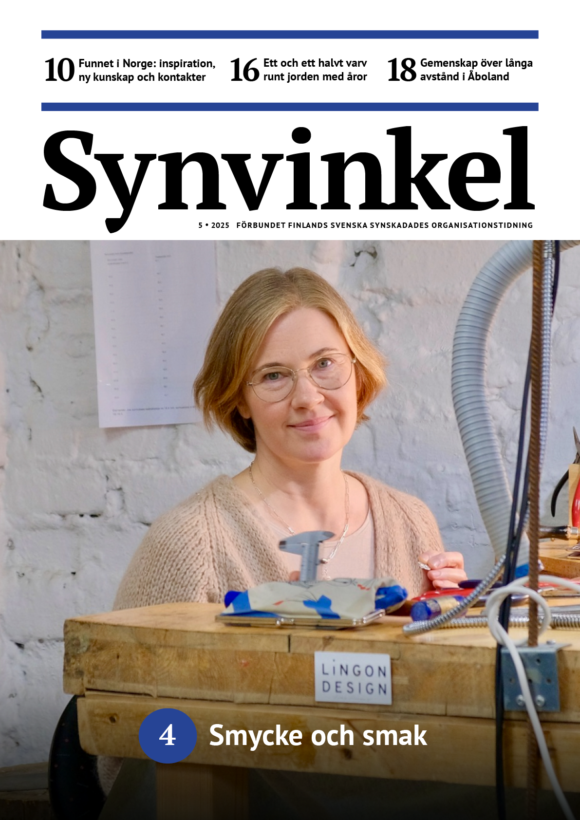 En leende kvinna med ljust hår och glasögon sitter vid en arbetsbänk av trä. Hon bär en ljus stickad kofta och håller i ett litet verktyg. På en liten skylt framtill på bänken står texten ”Lingon Design”.