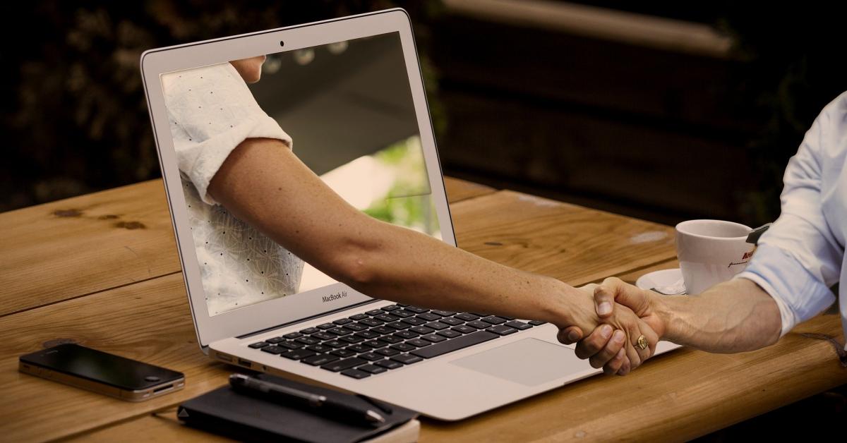 Två som skakar hand genom en datorskärm. Bild: Pixabay
