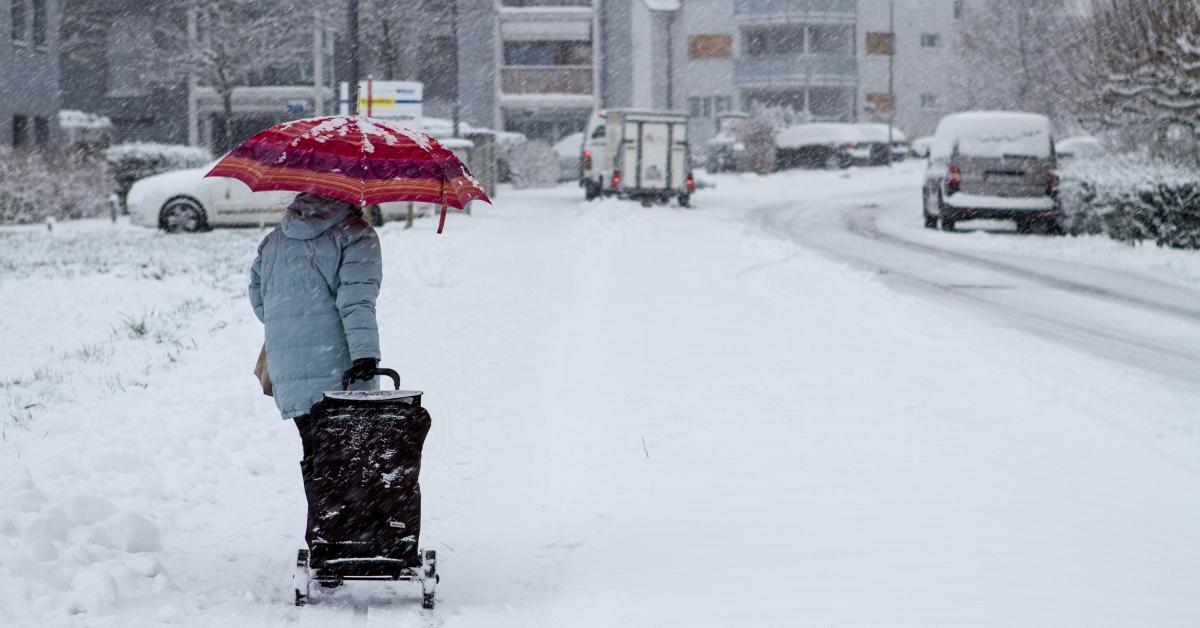 En kvinna går på en snöig gata